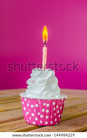 White cream cupcake with candle