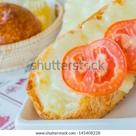 Cheese bread with tomato on top in white dish