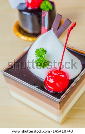 Vanilla , Chocolate , Coffee layer cake with cherry on top