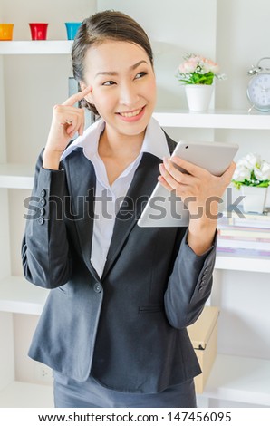 Young business woman thinking and use tablet with smiling