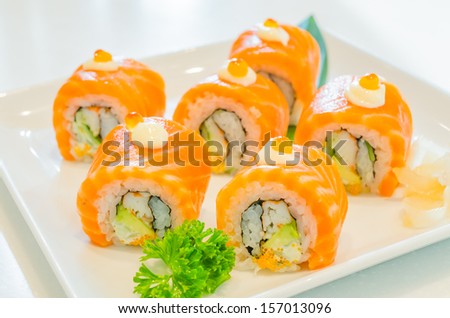 Salmon roll sushi with salmon egg on top in white dish