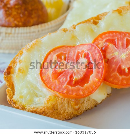 Cheese bread with tomato on top in white dish