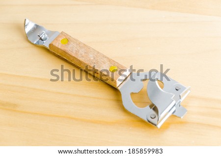 Can opener on wood background