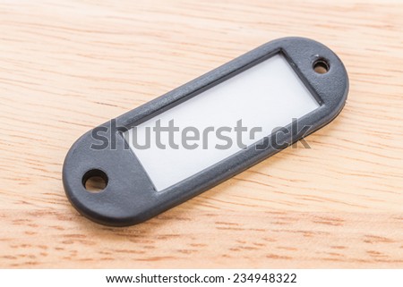 Name tag luggage on wooden background