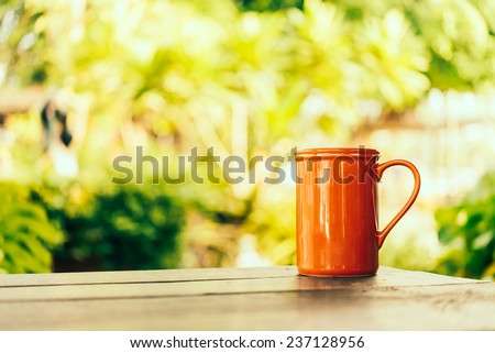 Red Coffee mug on wooden table in coffee shop - Vintage effect style pictures processing