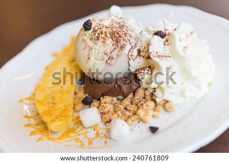 Vanilla ice cream with banana and whipping cream in white plate