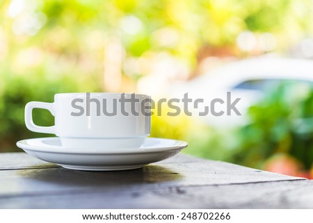 Coffee cup on wooden table outdoor background