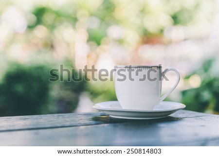 Coffee mug on wooden table outdoor background - Vintage effect style pictures