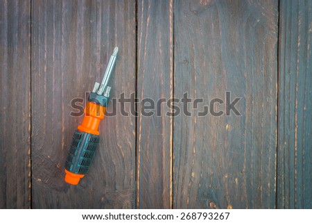 Screw driver on wooden background - vintage effect style pictures