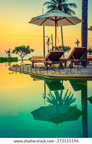 Twilight time Sunset umbrella deck chair pool - vintage filter effect