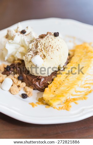 Vanilla ice cream with banana and whipping cream in white plate