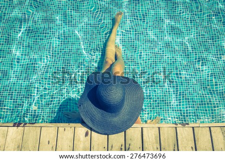 Woman hat in swimming pool - vintage filter