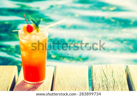 Fruit cocktail glass at pool - vintage filter effect