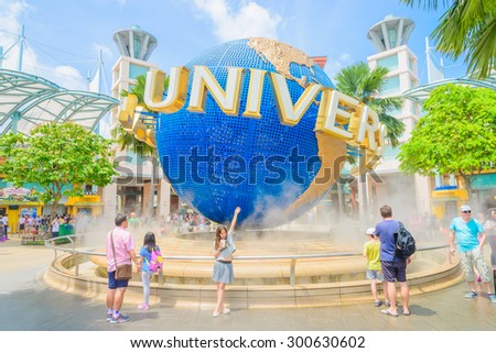 SINGAPORE - JULY 20: Tourists and theme park visitors taking pictures of the large rotating globe fountain in front of Universal Studios on JULY 20, 2015 in Sentosa island, Singapore