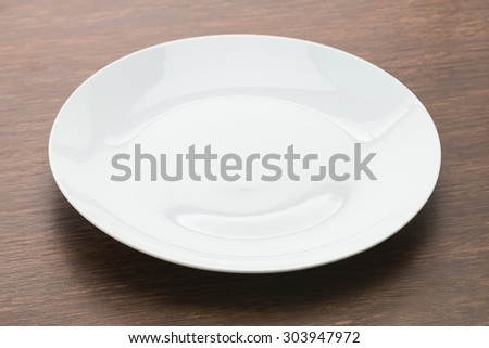 Empty white plate dish on wooden background