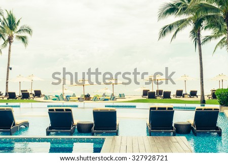 Beautiful Luxury Swimming pool with umbrella and chair in hotel resort - vintage filter