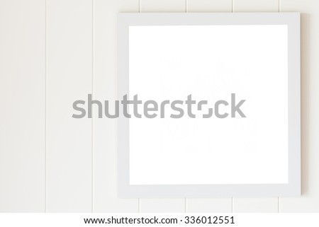 Blank photo frame on white wood wall background