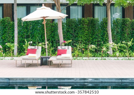 Umbrella and chair deck in hotel resort swimming pool - Filter effect