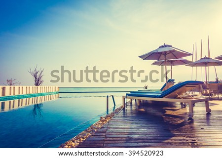 Beautiful luxury swimming pool in hotel resort with umbrella and chair in sunset times - Vintage Filter and Boost up color processing