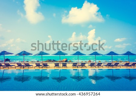 Beautiful luxury umbrella and chair around outdoor swimming pool in hotel resort neary sea and beach - Vintage Filter