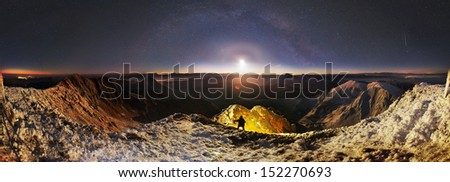 Moonrise over Mika-Mare, in the Carpathian Mountains. The slope of the frozen mountains lit by a powerful LED light warm light, to achieve a fantastic effect \