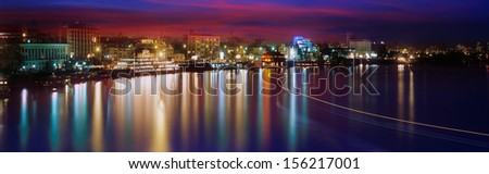 Sunrise and sunset on the Dnieper, Dnipro, Dnepr on the background of glowing streets of ancient Kiev, majestic and romantic, flowing water erodes the glow and the air above the city lights up in red