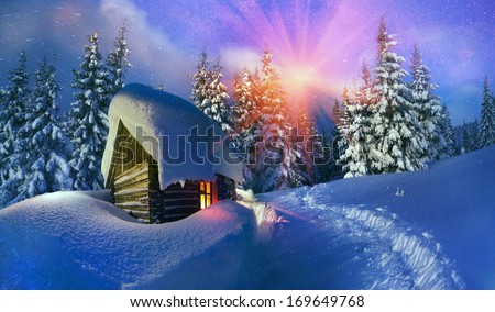 Beautiful wooden house as Santa Claus, with glowing window is located at the beginning of the lifting of the alpine heights. Climbers spend the night here and in morning go to the top to meet  new day