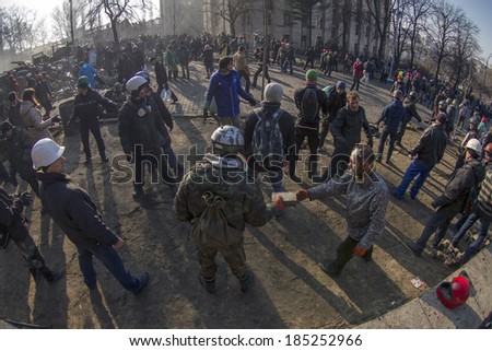 Kiev, Ukraine - February 20, 2014: Freed from government troops Evromaydan. The smoke protesters hiding from snipers, collecting stones and bottles at the devastated area to the forward position,