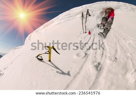 lone climber at the summit of severe weather conditions on the background of winter high mountains, among the alpine steep slopes and sharp ridges. Security against wind and avalanches