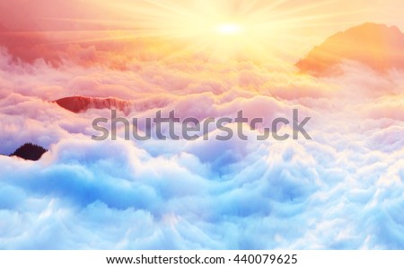 Bright saturated colors dawn above the sea of fog over the tops of the Carpathian is fabulously beautiful panoramic view, illuminated by the golden rays of the rising sun early in the morning