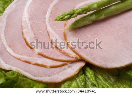 Close-up shot of a ham with lettuce and asparagus