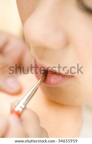 LIFESTYLE IMAGE-a woman painting up her lip