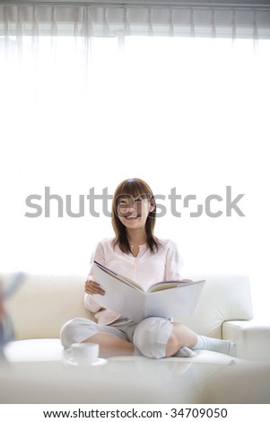 LIFESTYLE IMAGE-a Japanese woman sitting on the couch and reading the book