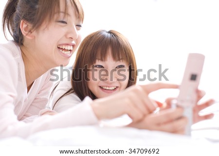 LIFESTYLE IMAGE-two Japanese women looking at cell phone