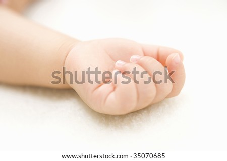 LIFESTYLE IMAGE-close-up shot of a tiny hand of baby