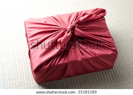 SEASONAL IMAGE-a gift box wrapped with red Japanese traditional cloth ; FUROSHIKI