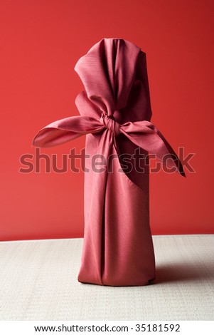 SEASONAL IMAGE-a gift wrapped with red Japanese traditional cloth ; FUROSHIKI