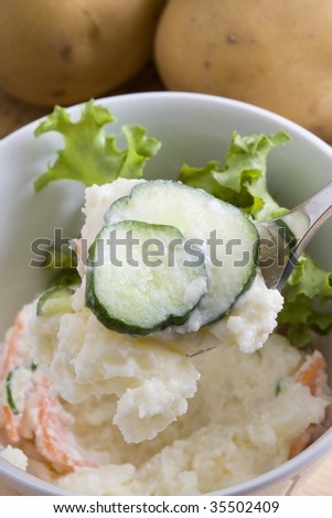 Close-up shot of potato salad with fresh potatoes