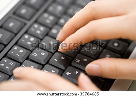 BUSINESS IMAGE- close-up shot of woman\'s fingers typing the black keyboard
