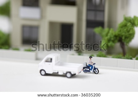 A model of track and a man riding his bike on the street