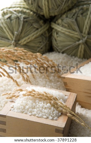 Three straw rice bags and a lot of fresh rice.