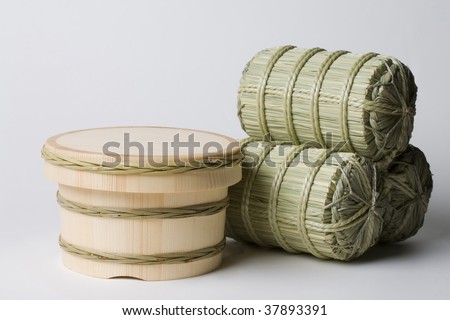 Three straw rice bags and rice chest are placed on the floor.
