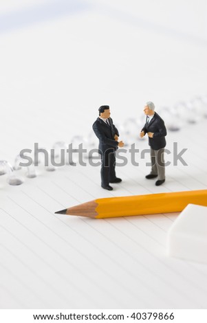 Figures of the businessman who lines up on the notebook and big pencil.