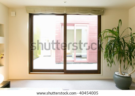 Bedroom with a big window and a plant.
