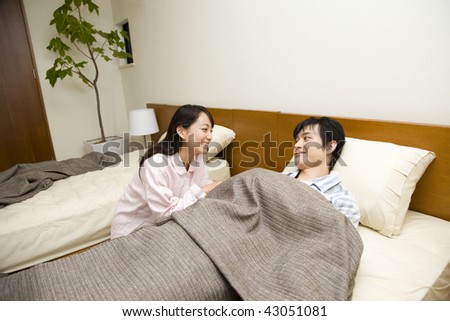Young man and woman chatting on the bed