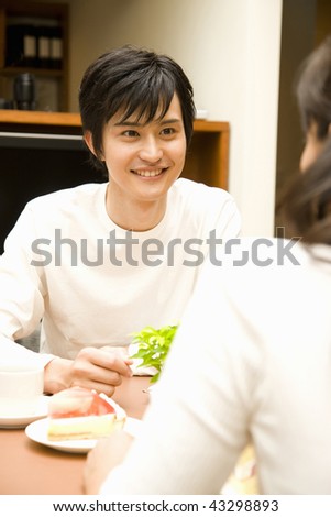 A young man chatting with a young woman and smiling