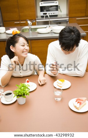 A young couple chatting and eating in the kitchen
