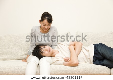 A young man laying his head on woman\'s lap