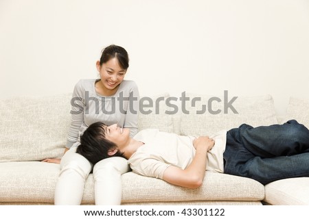 A young man laying his head on woman\'s lap