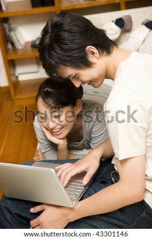 A young man watching PC with laying young woman